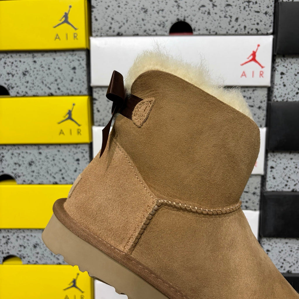 UGG Mini Bailey Bow Ankle Boot – Suede Boot with Cream Shearling Lining, Dark Chocolate Satin Bow & Tan Sugar Sole in Chestnut